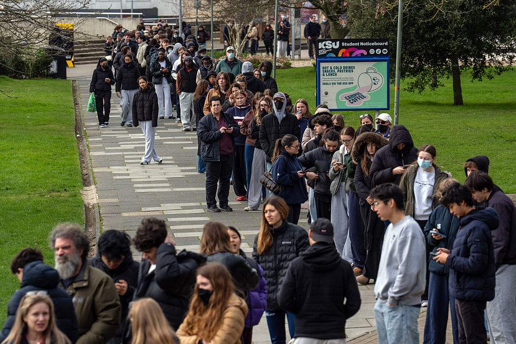 Staff and students, some wearing face masks, queue to receive antibiotics at the University of Kent in Canterbury after an outbreak of meningitis caused the deaths of two people, on March 16, 2026 in Canterbury, United Kingdom. Two people have died amid an outbreak of meningitis at the University of Kent in Canterbury. Thirteen cases have been reported since Friday, reportedly affecting university students aged between 18 and 21.