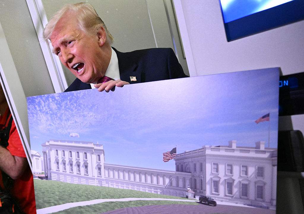 U.S. President Donald Trump holds a rendering of the East Wing modernization as he speaks to reporters aboard Air Force One en route to Joint Base Andrews, Maryland, on March 29, 2026.