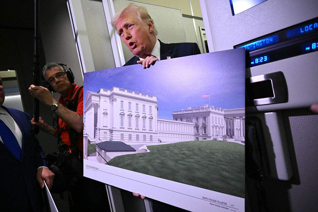 President Donald Trump holds a rendering of the East Wing modernization as he speaks to reporters aboard Air Force One en route to Joint Base Andrews, Maryland, on March 29, 2026.
