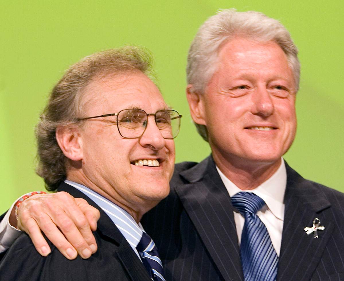 Former US president Bill Clinton (right) embraces UN Special Envoy for HIV/AIDS in Africa Stephen Lewis after speaking at the 16th World Aids Conference in Toronto on Tuesday August 15, 2006. (CP PHOTO/Frank Gunn)