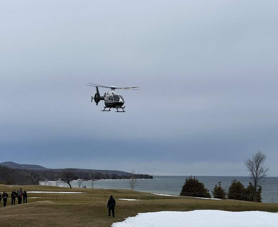 Ontario Provincial Police officers and a helicopter are shown in this handout photo. Ontario police say 23 people needed to be rescued when they were stranded on an ice shelf in Georgian Bay. They say the ice drifted for about two kilometres and split into several sections, causing some people to become partially submerged in the icy water.  edit).