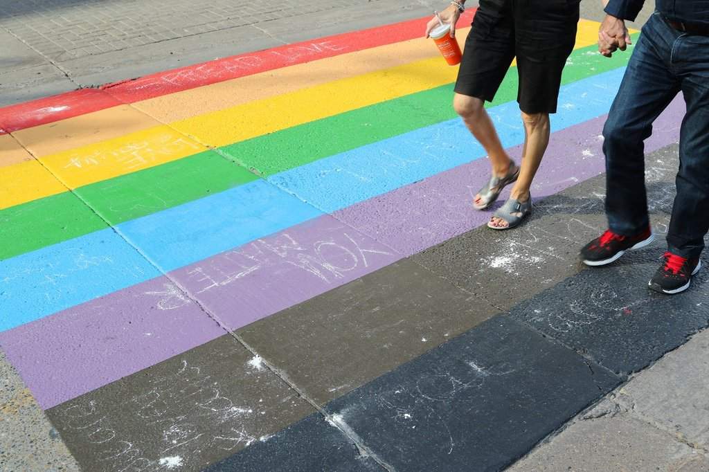 People walk on a Pride flag crosswalk in Calgary on Sunday, Aug. 18, 2019.  