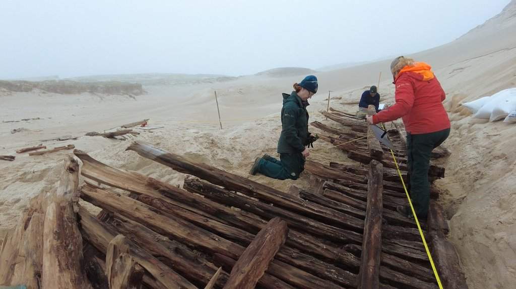 Parks Canada archeologists take measurements of an exposed deck section believed to be from the Swift, a sloop that shipwrecked on Sable Island in September 1812, in this handout photo, at Sable Island National Park Reserve, N.S., on May 17, 2025. THE CANADIAN PRESS/Handout - Parks Canada (Mandatory Credit).