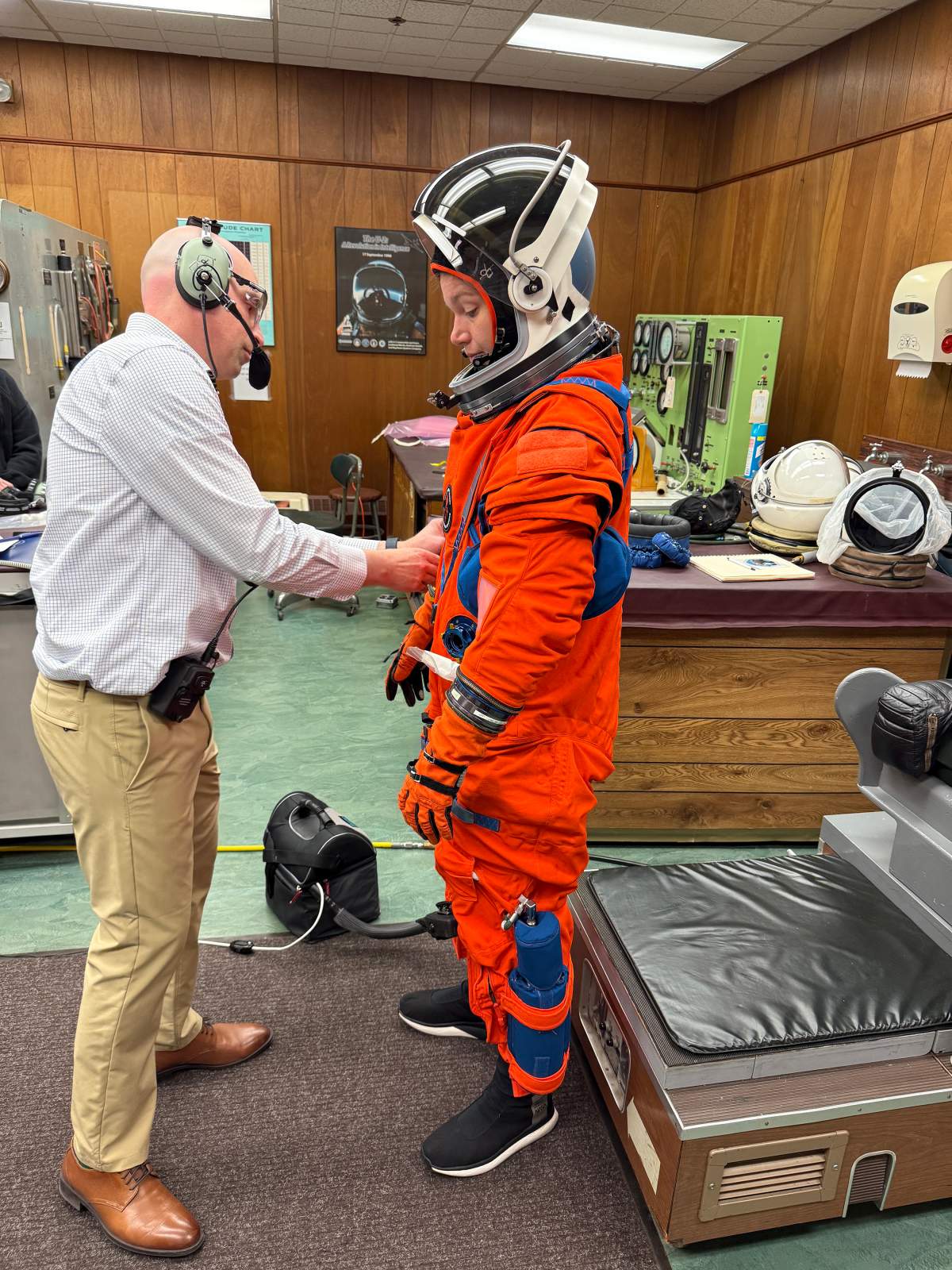 Canadian Space Agency astronaut Jenni Gibbons has her suit adjusted as she conducts a long-duration fit check, practising several operations while under various suit pressures, in an undated handout photo. )
