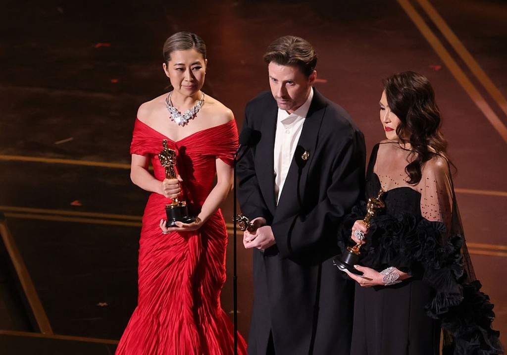 (L-R) Maggie Kang, Chris Appelhans, and Michelle Wong accept the Animated Feature Film for "KPop Demon Hunters" onstage during the 98th Oscars at Dolby Theatre on March 15, 2026 in Hollywood, California.