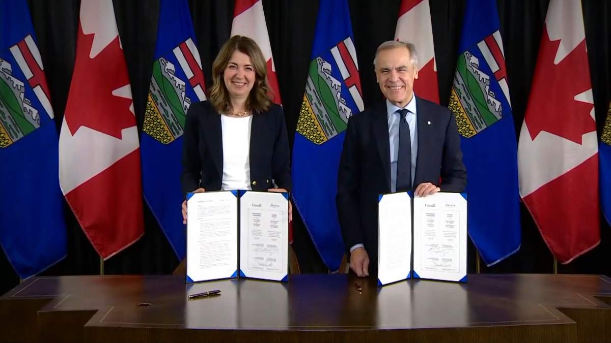 Prime Minister Mark Carney and Alberta Premier Danielle Smith celebrate their signing of a "Memorandum of Understanding" on construction of a new pipeline to the west coast during a ceremony in Calgary in November 2025.