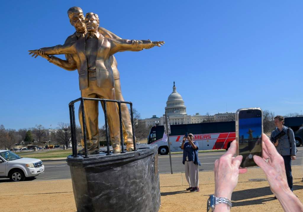 People take photos of protest art representing President Donald Trump and Jeffrey Epstein on the National Mall near the Capitol, Tuesday, March 10, 2026, in Washington.