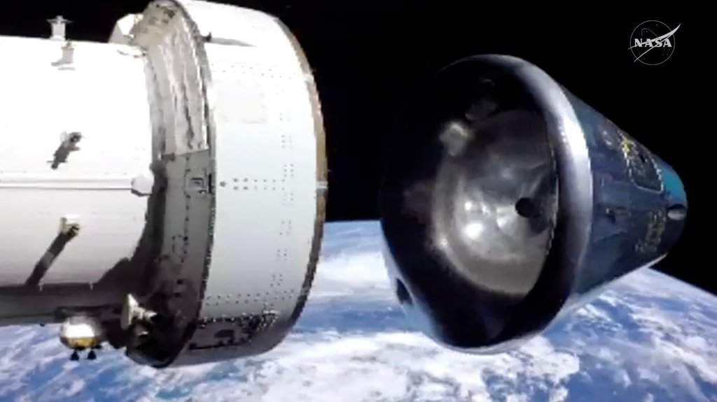 In this image from video provided by NASA, the Artemis II Orion capsule, right, separates from the service module above the Earth in preparation for splash down in the Pacific Ocean.