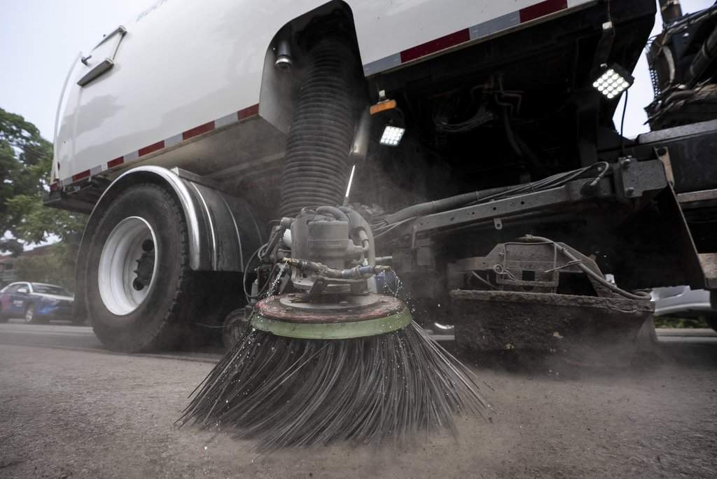 Street cleaning vehicles sweep the street following flash flooding after heavy rains in Montreal on Monday July 14, 2025. 