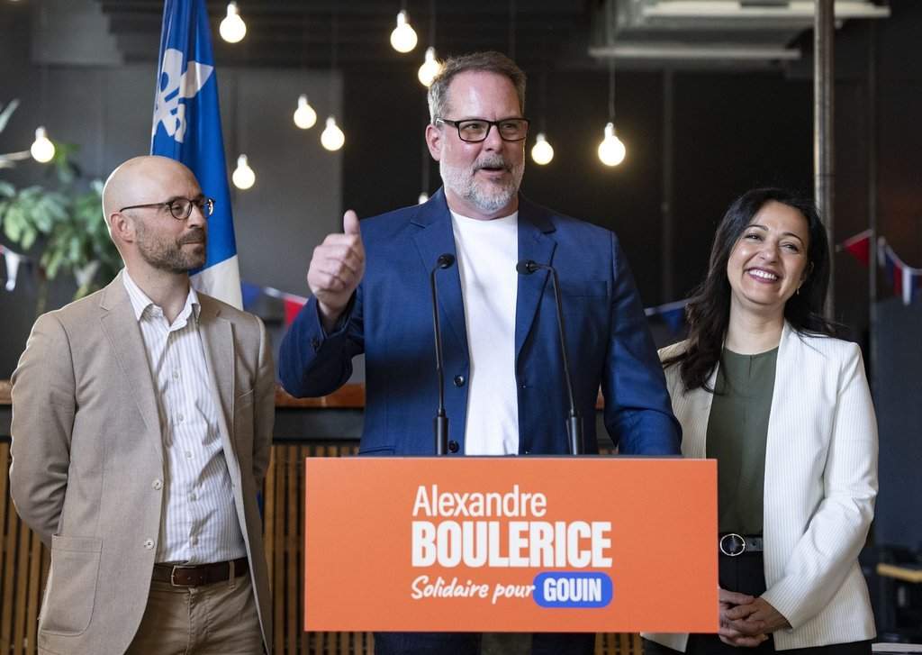 Alexandre Boulerice, centre, federal MP for the riding of Rosemont-La Petite-Patrie flanked by Quebec Solitaire co-spokesperson Ruba Ghazal, right, and Sol Zanetti gives a thumbs up as he announces his intention to leave federal politics and the NDP party to run provincially with Quebec Solidaire, in Montreal on Monday, April 27, 2026. THE CANADIAN PRESS/Christinne Muschi.