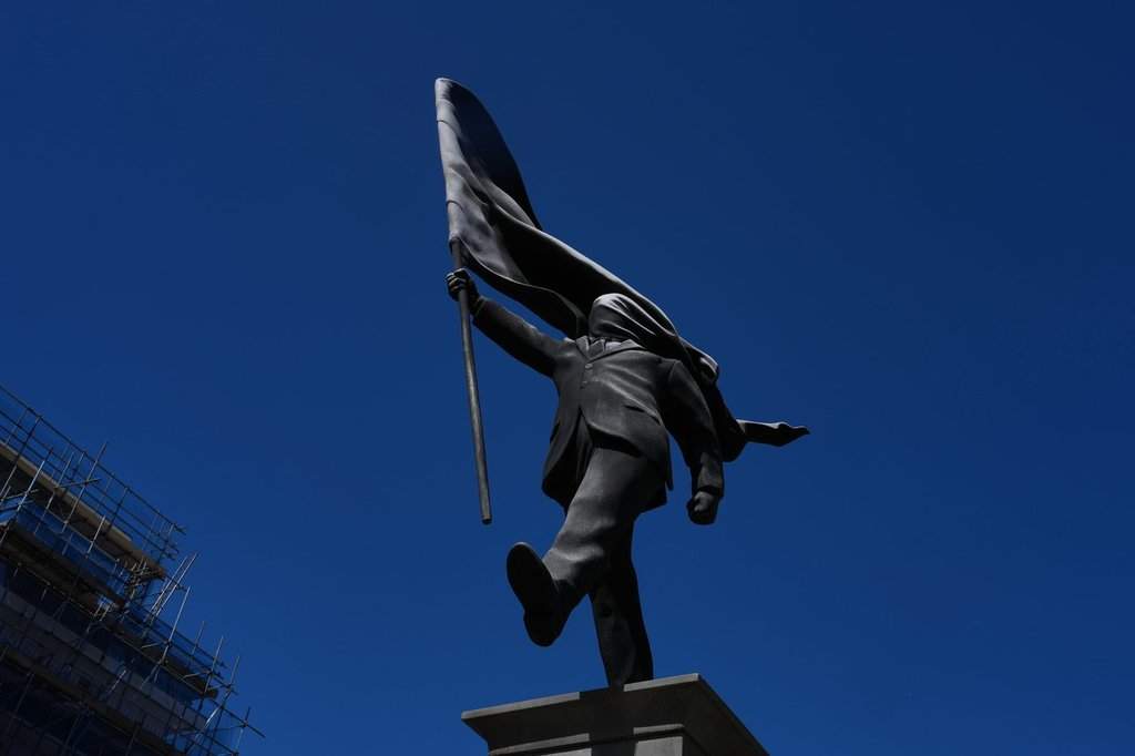 A statue of a man holding a flag covering his face, and signed 'Banksy', which has appeared in Waterloo Place in London, Thursday, April 30, 2026