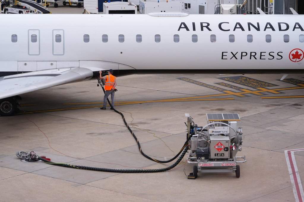 FILE: A worker fuels an Air Canada jet at DFW International Airport in Grapevine, Texas, Tuesday, April 14, 2026.