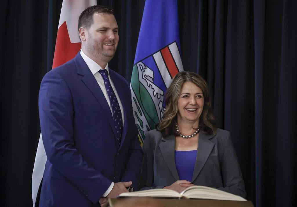 Alberta Premier Danielle Smith, right, stands with new Minister of Jobs, Economy, Trade, and Immigration, Joseph Schow, following a swearing in ceremony in Calgary, Friday, May 16, 2025.
