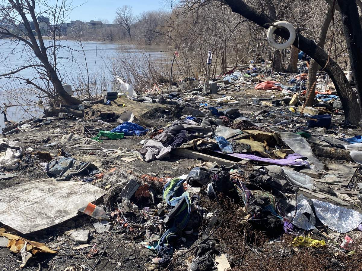 Garbage along the bank of the Red River near a number of encampments