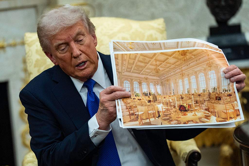 U.S. President Donald Trump speaks holding a photos of the new ballroom during a meeting with NATO Secretary General Mark Rutte in the Oval Office of the White House in Washington, DC on October 22, 2025.