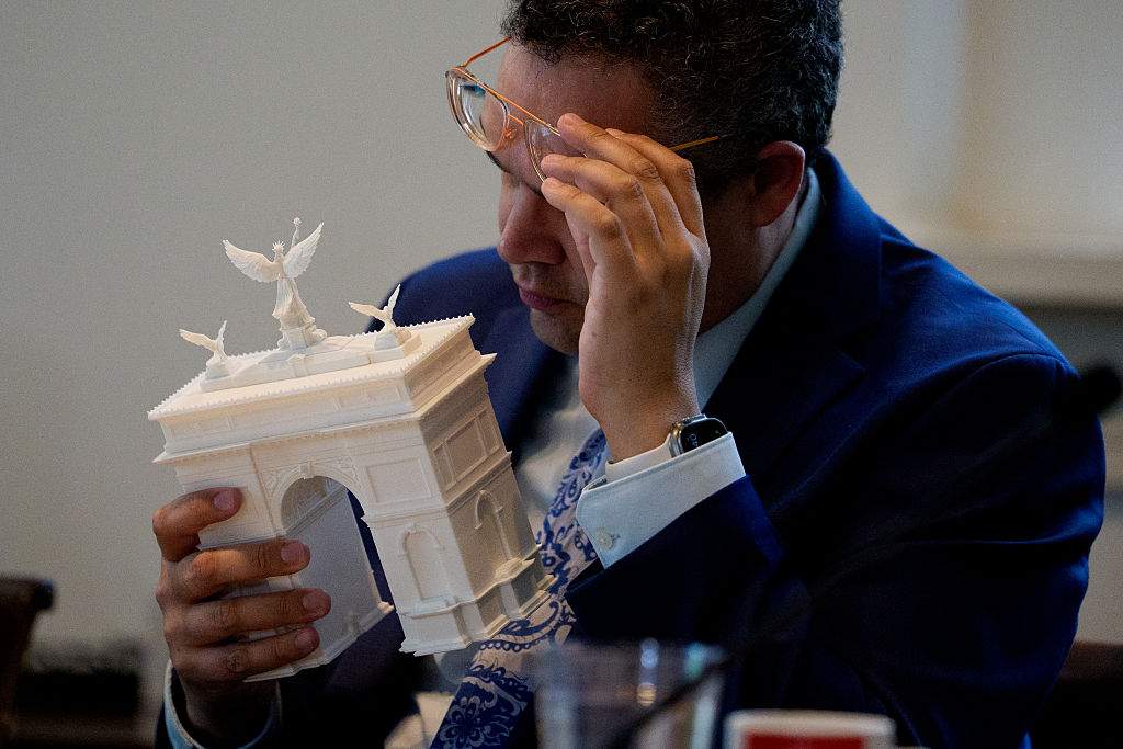 Commission of Fine Arts commission member Matthew Taylor inspects a model of President Donald Trump's proposed triumphal arch to commemorate the country's 250th anniversary during a public meeting of the Commission of Fine Arts at the National Building Museum on April 16, 2026 in Washington, DC.
