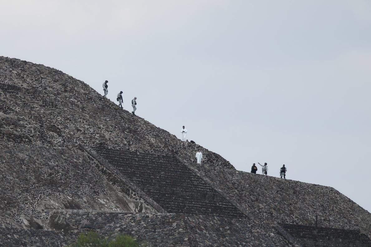 Police and forensic workers stand on the pyramids after authorities said a gunman opened fire in Teotihuacan, Mexico, Monday, April 20, 2026. (AP Photo/Eduardo Verdugo)