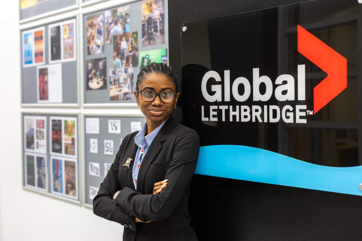 Patience Omeruo posing in front of a Global Lethbridge sign.