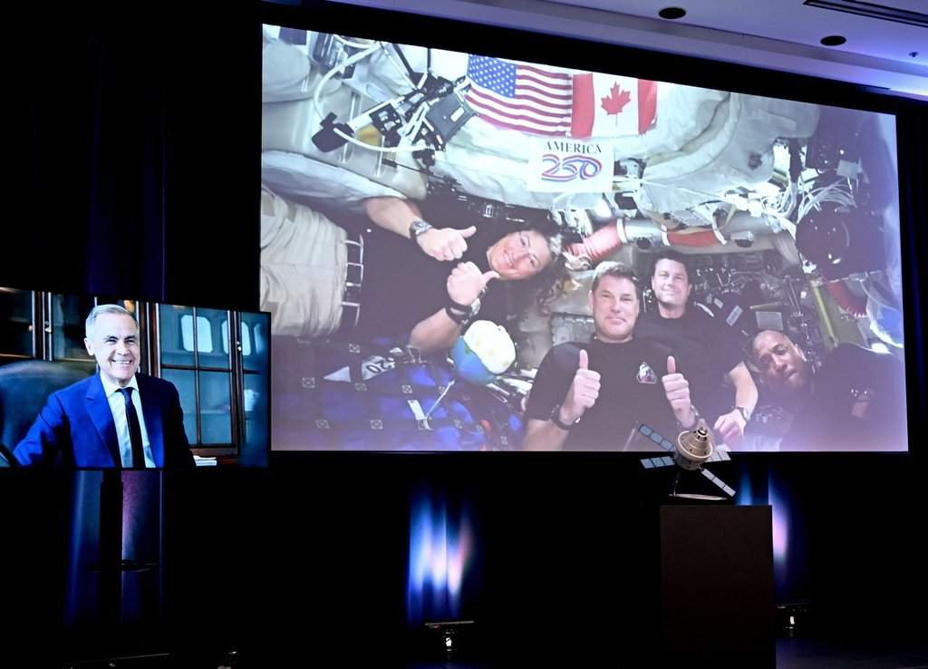 Prime Minister Mark Carney, left, speaks to Artemis II mission astronauts, left to right, Christina Koch, Jeremy Hansen, Reid Wiseman and Victor Glover during a live feed at the Canadian Space Agency headquarters in Longueuil, Que., Wednesday, April 8, 2026.