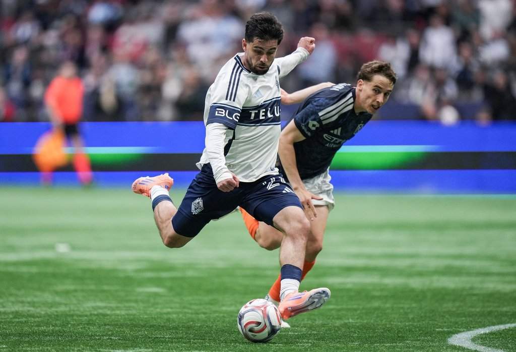 Vancouver Whitecaps' Brian White, front, takes a shot on goal as New York City FC's Kai Trewin watches during the second half of an MLS soccer match, in Vancouver, on Saturday, April 11, 2026. THE CANADIAN PRESS/Darryl Dyck.