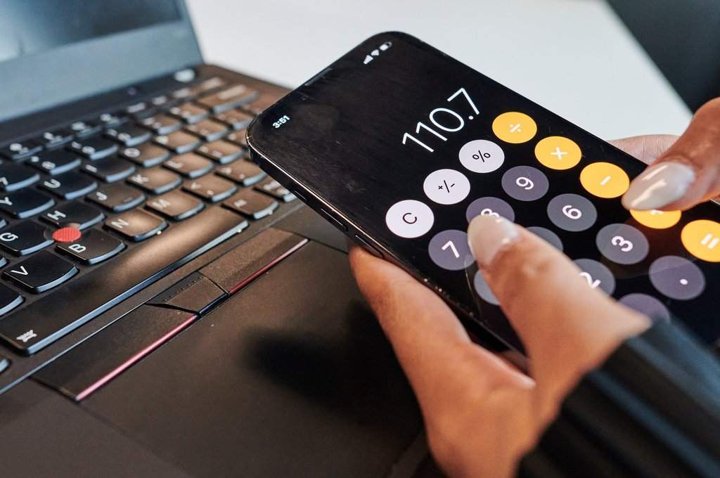 A person uses the calculator app on their phone in a photo illustration made in Toronto, on Monday, Sept. 22, 2025. 