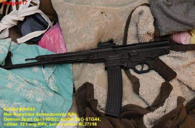 Evidence photograph taken by police in the Shewchuk apartment of the rifle used in the shootings, once it was placed on a couch on March 16, 2023.