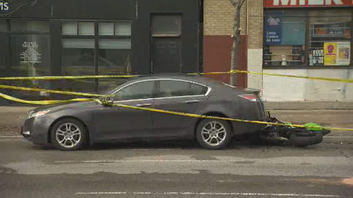 A motorcycle sits under the back bumper of a parked vehicle. The driver of the motorcycle died from his injuries after his bike hit the vehicle. 