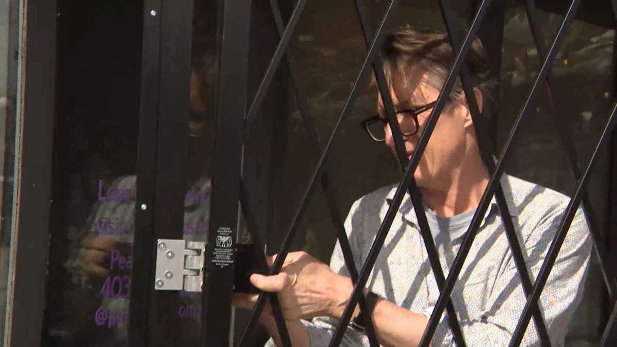 Greg Jarmula, Manager of Walls Alive, says he had to install a steel security gate after a fire was recently started at the front door of his business.
