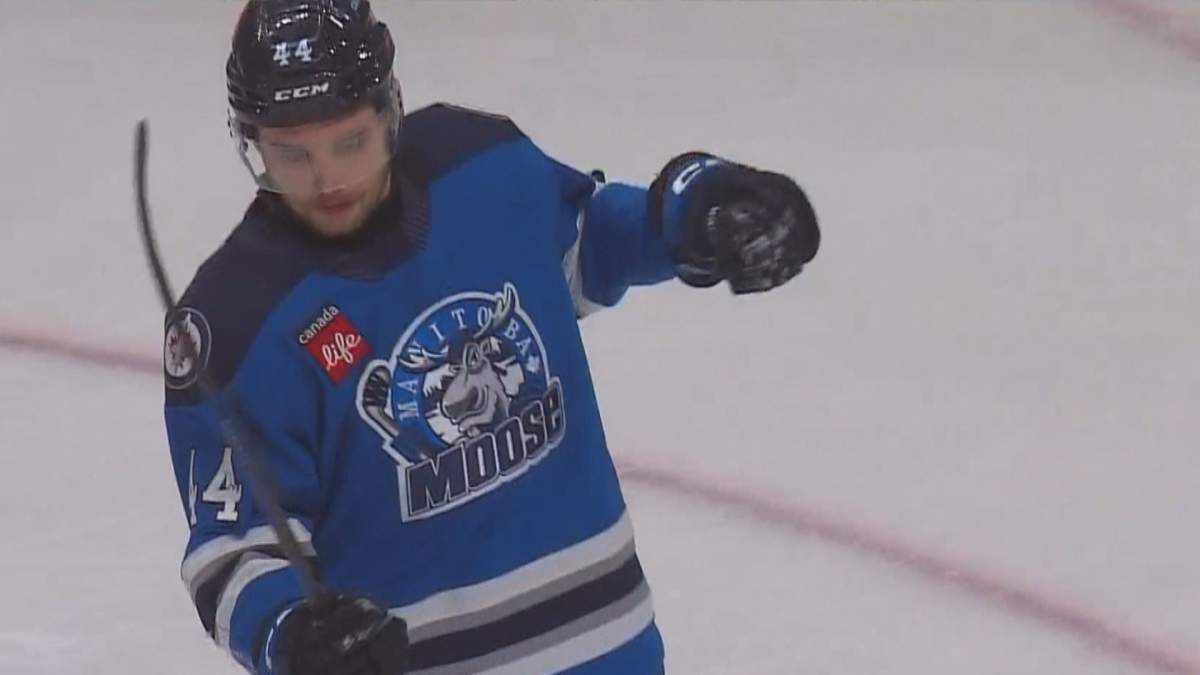Manitoba Moose defenceman Elias Salomonsson tests his shoulder after falling into the boards.