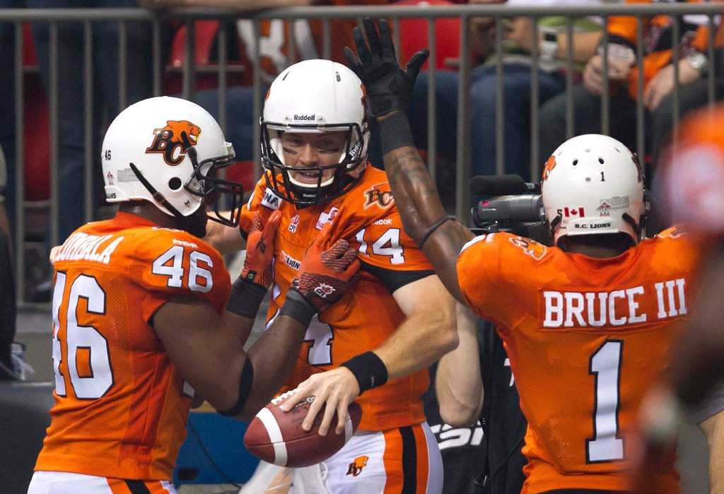 B.C. Lions' Rolly Lumbala, from left, quarterback Travis Lulay and Arland Bruce III celebrate Lulay's touchdown against the Winnipeg Blue Bombers during the first half of a CFL football game in Vancouver, B.C., on Friday, June 29, 2012. THE CANADIAN PRESS/Darryl Dyck.