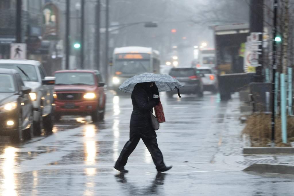 A pedestrian walks through the rain and wind during a rainfall warning in Halifax on Thursday, Jan. 26, 2023. 