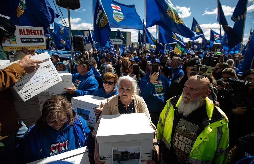 Supporters carry boxes of signatures to submit for a separation referendum to Elections Alberta in Edmonton, on Monday, May 4, 2026.