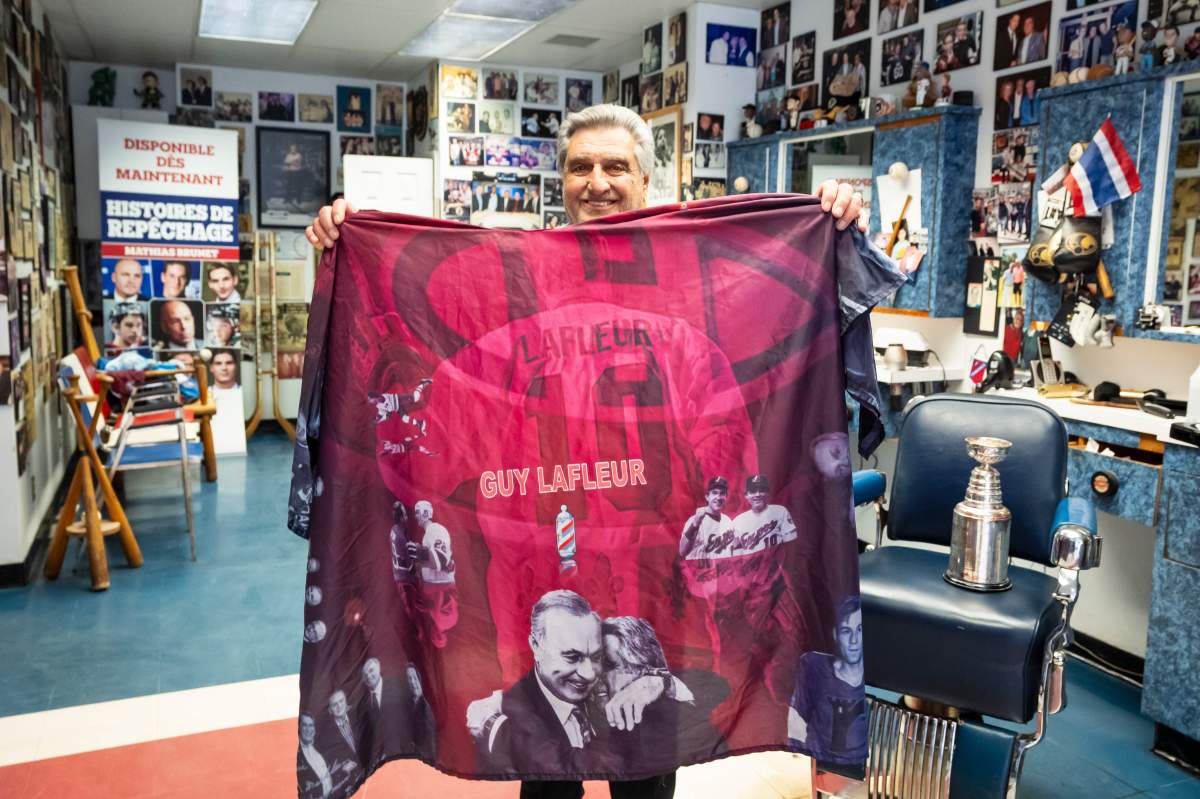 Menick poses for a photograph at his barbershop with an apron dedicated to Montreal Canadiens player Guy Lafleur, in Montreal, on Thursday, May 7, 2026. THE CANADIAN PRESS/Christopher Katsarov
