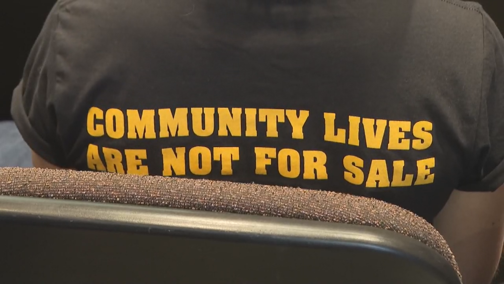 A shirt worn to Lethbridge council chambers reading 'community lives are not for sale'.