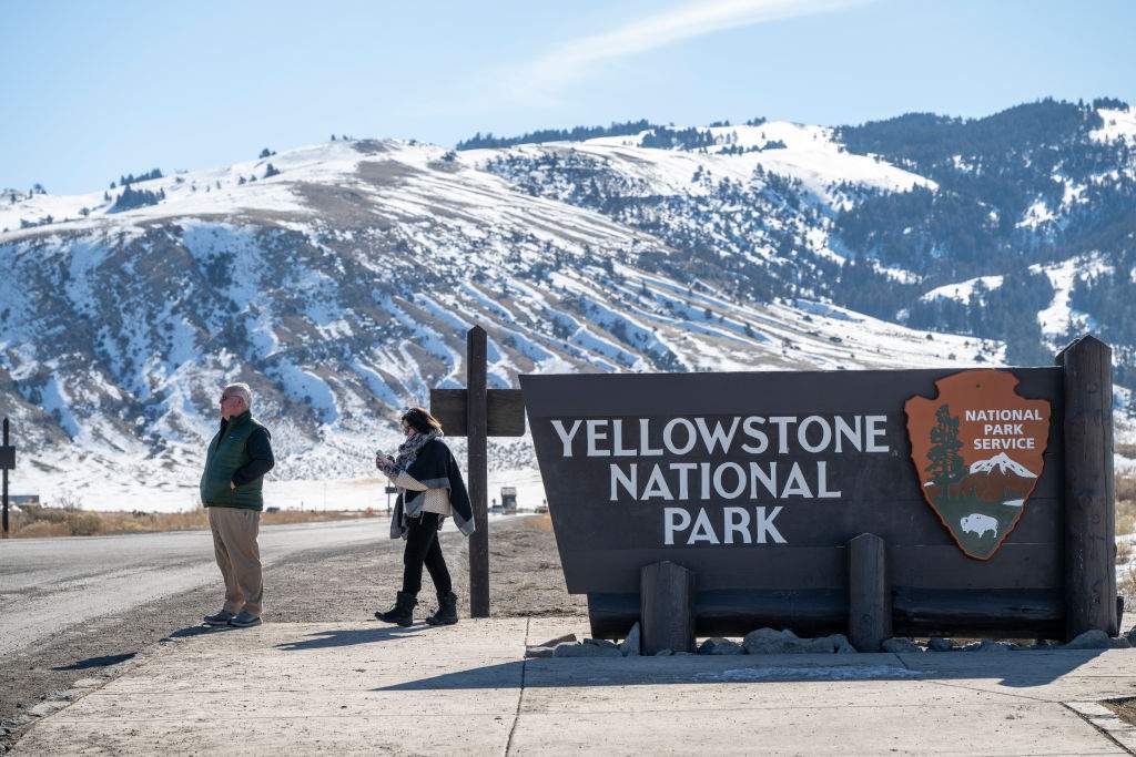 GARDINER, MT - MARCH 02: Visitors take photos at the northern entrance to Yellowstone National Park on March 2, 2025 in Gardiner, Montana.