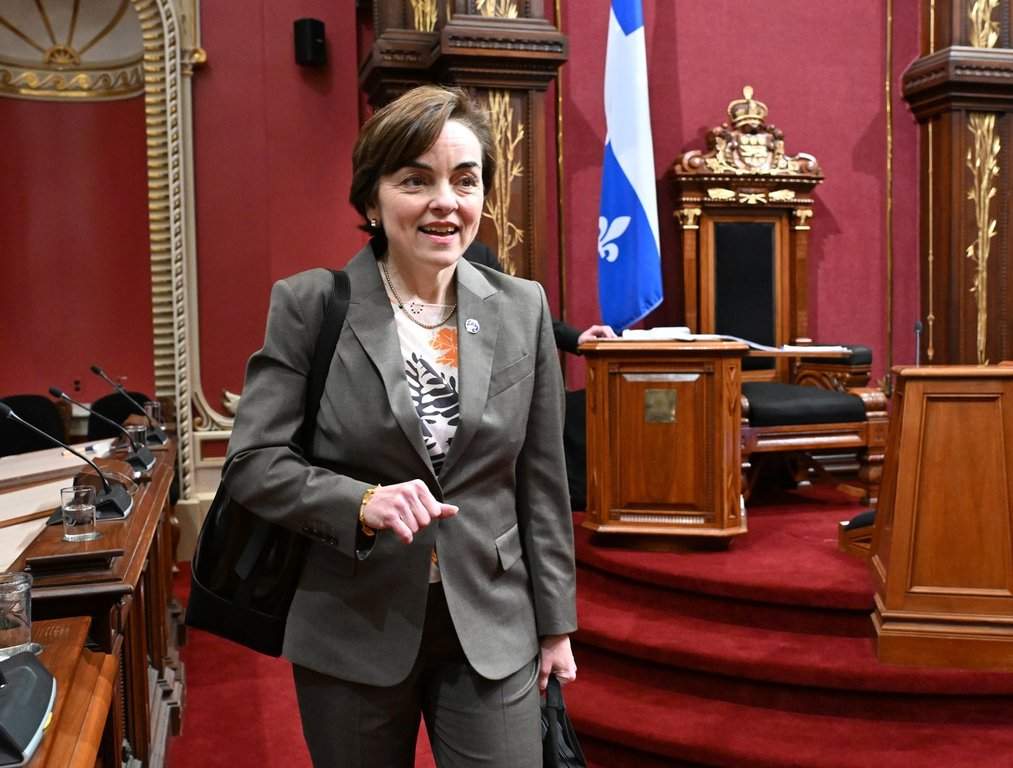 Quebec Premier Christine Frechette smiles as she walks to her seat for question period. 