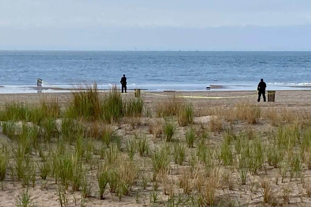 New York Police investigators examine a stretch of beach at Coney Island where three children were found dead in the surf, Sept. 12, 2022, in New York.