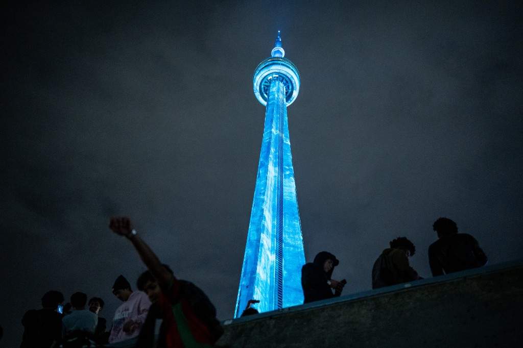 Fans of Drake climb a concrete structure as they gather near the CN Tower for a video projection promoting the upcoming album 'ICEMAN' in Toronto on Friday, May 14, 2026.
