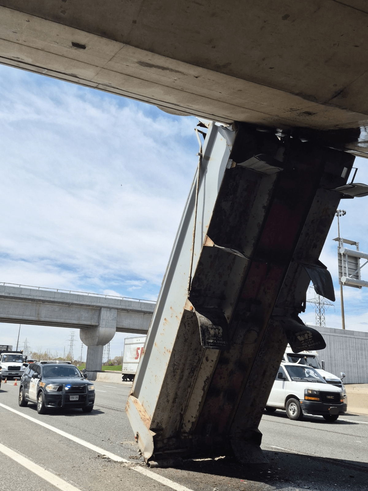 A dump truck wedged under a bridge on Highway 403.
