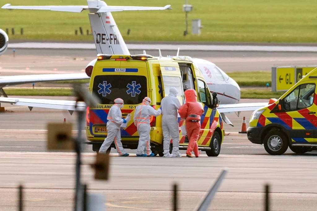 Medics escort a patients, evacuated from the MV Hondius cruise ship with suspected hantavirus infection, to an ambulance after being flown to Schiphol airport, Amsterdam, Netherlands, Wednesday, May 6, 2026.