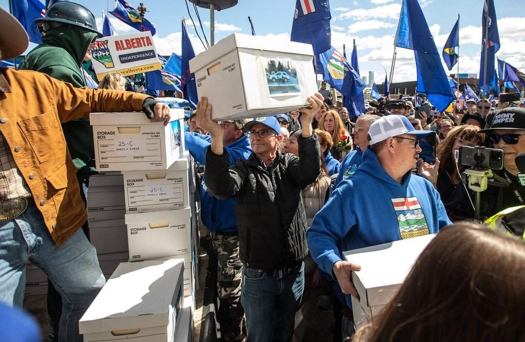 Supporters carry boxes of signatures to submit for a separation referendum to Elections Alberta in Edmonton, on Monday, May 4, 2026. 