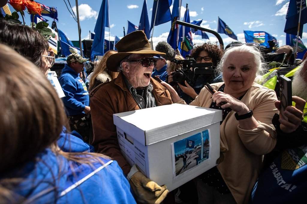 Supporters carry boxes of signatures to submit for a separation referendum to Elections Alberta in Edmonton, on Monday, May 4, 2026. 