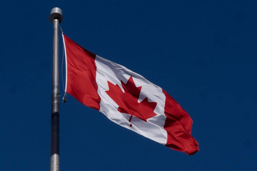 The Canadian flag is seen flying behind the National Archives building in Ottawa Friday, Feb. 14, 2025 in Ottawa.   