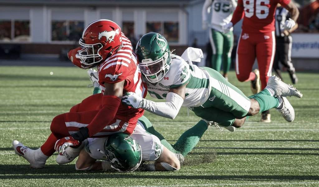 Saskatchewan Roughriders' DaMarcus Fields, right, tackles Calgary Stampeders' Dedrick Mills during second half CFL football action in Calgary, Saturday, Aug. 23, 2025.THE CANADIAN PRESS/Jeff McIntosh.