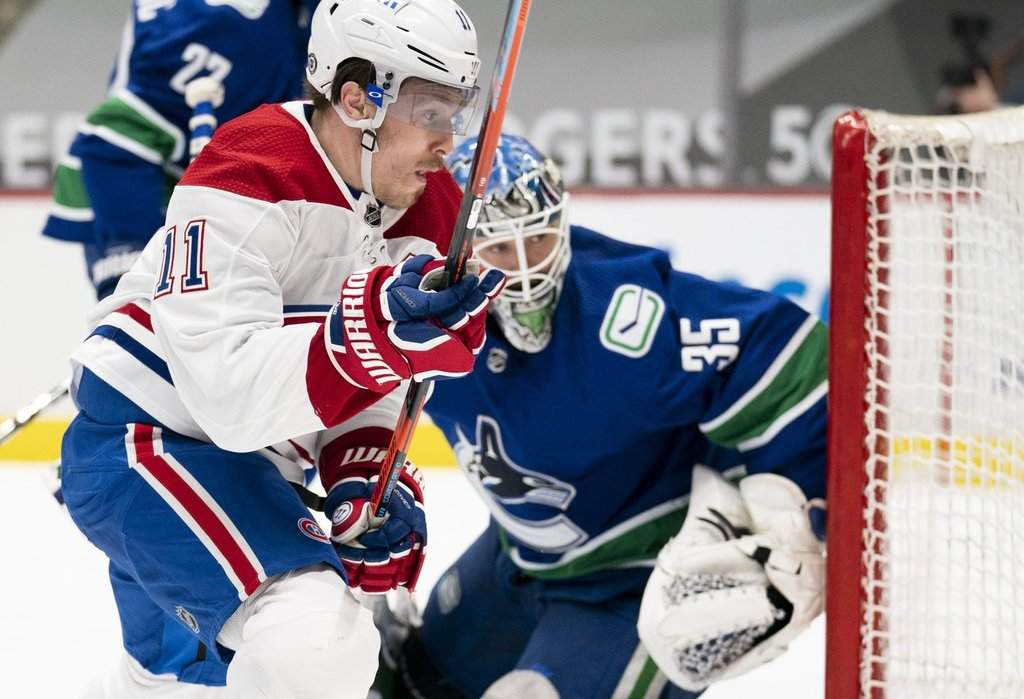 Montreal Canadiens right wing Brendan Gallagher (11) looks for the puck with Vancouver Canucks goaltender Thatcher Demko (35) during first-period NHL action in Vancouver, Wednesday, March 10, 2021.
