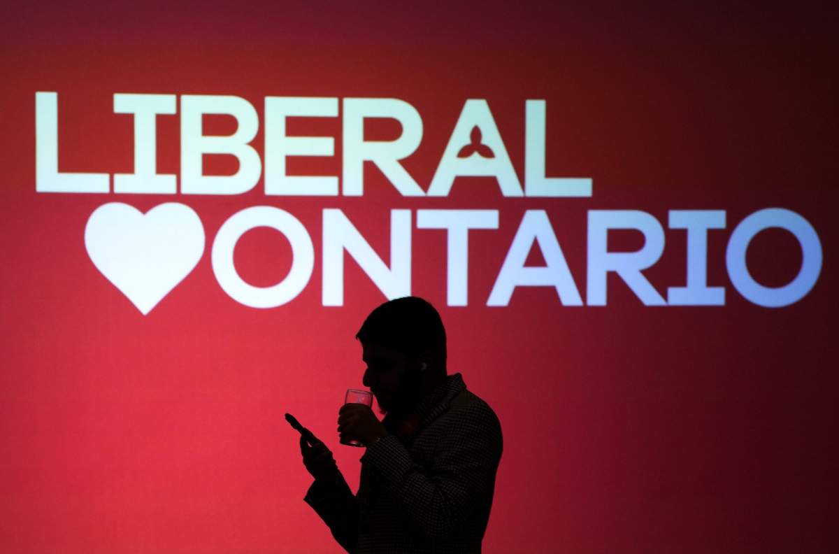 A person over looks their phone as polls get ready to close at the Ontario Liberal campaign headquarters during the Ontario provincial election in Mississauga, Ont., on Thursday, February 27, 2025. 