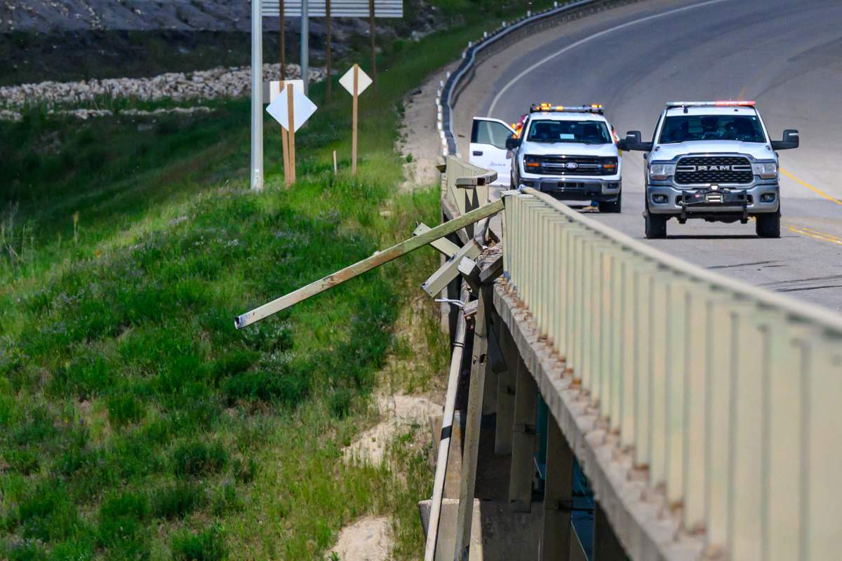 A damaged guardrail is pictured on the Wapiti River Bridge after a commercial crane drove off the bridge and went into the water, near Grande Prairie, Alta., on Tuesday, June 16, 2026.