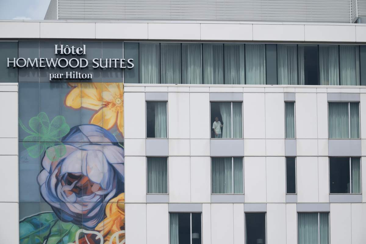 A person looks out a hotel window as police respond to a shooting in the Côte-des-Neiges district of Montreal on Monday, June 22, 2026.