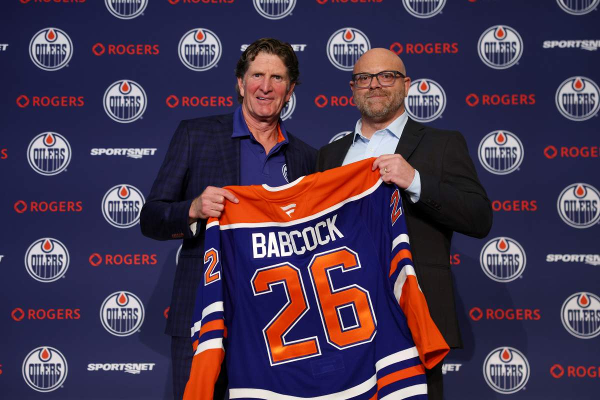 Edmonton Oilers head coach Mike Babcock, left, and general manager Stan Bowman hold up a jersey during a news conference in Edmonton on Tuesday, June 23, 2026.