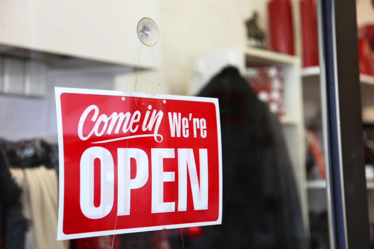A red open sign hangs from a store window. Lisa In Glasses/Getty Images